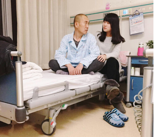 【张嘉乐正在医院的病床上陪伴身染重病的父亲】